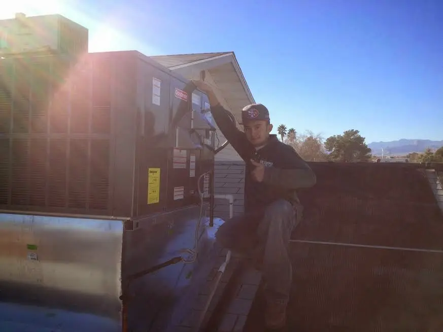 HVAC technician performing Heat Pump Repair on a rooftop unit in Superior